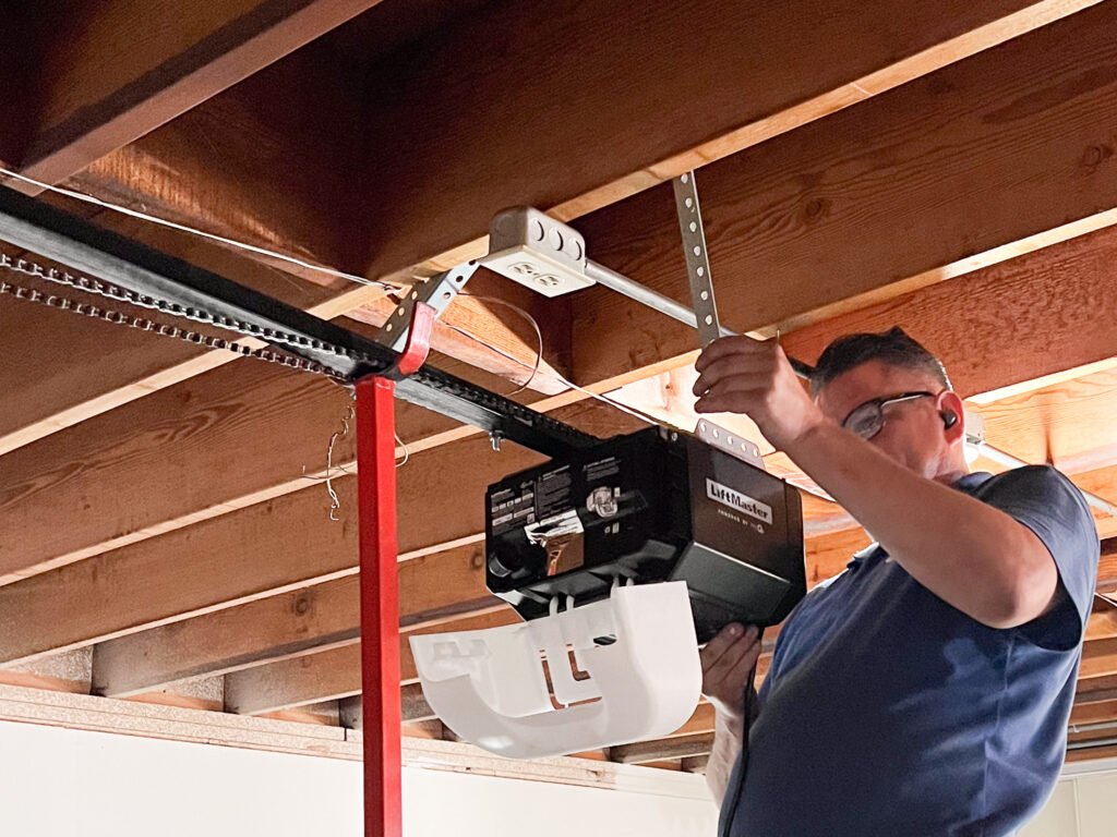 Technician installing a garage door opener motor